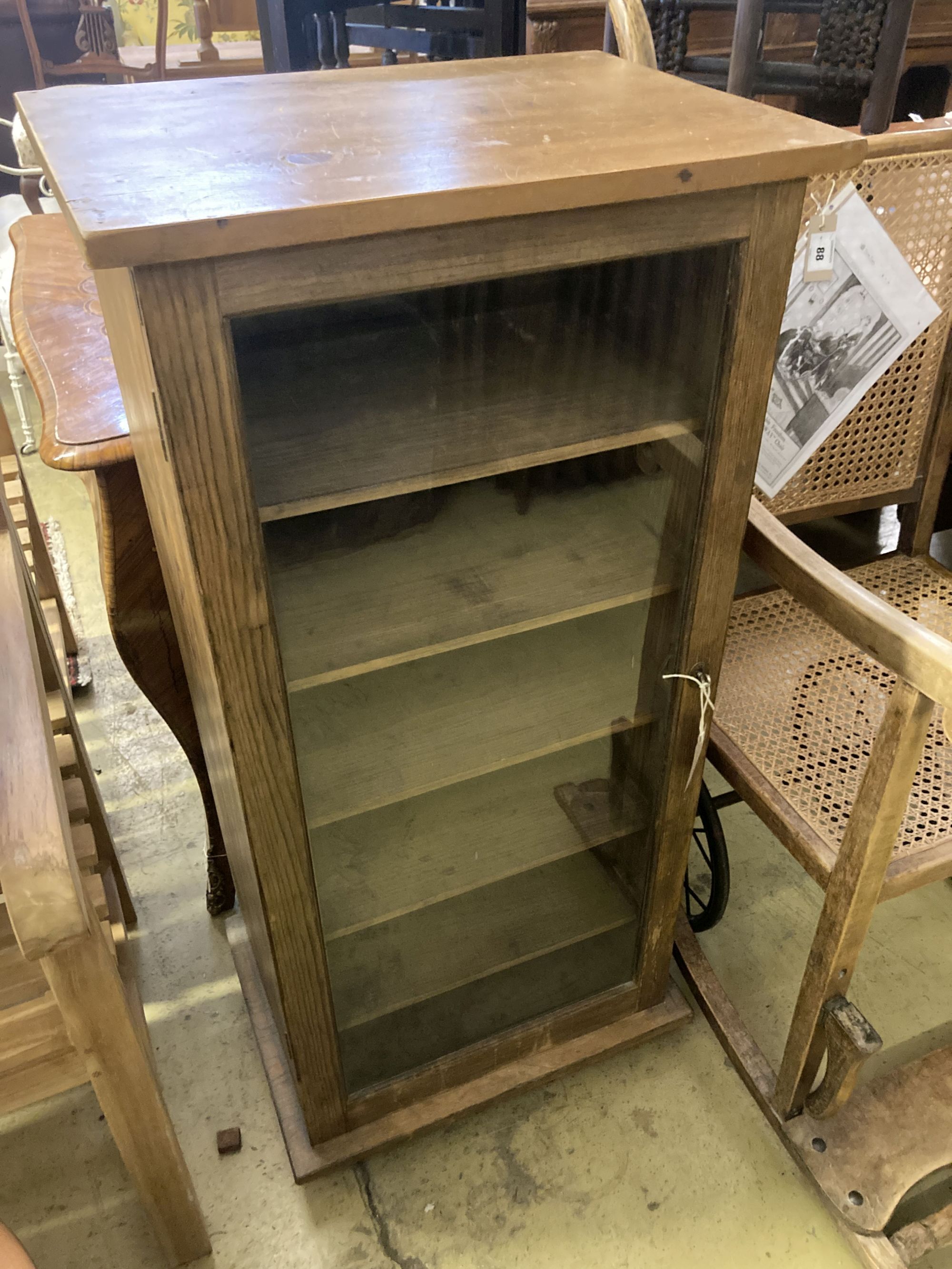 An oak and pine glazed music cabinet, glass fronted door with key, six shelves, width 52cm, depth 38cm, height 111cm